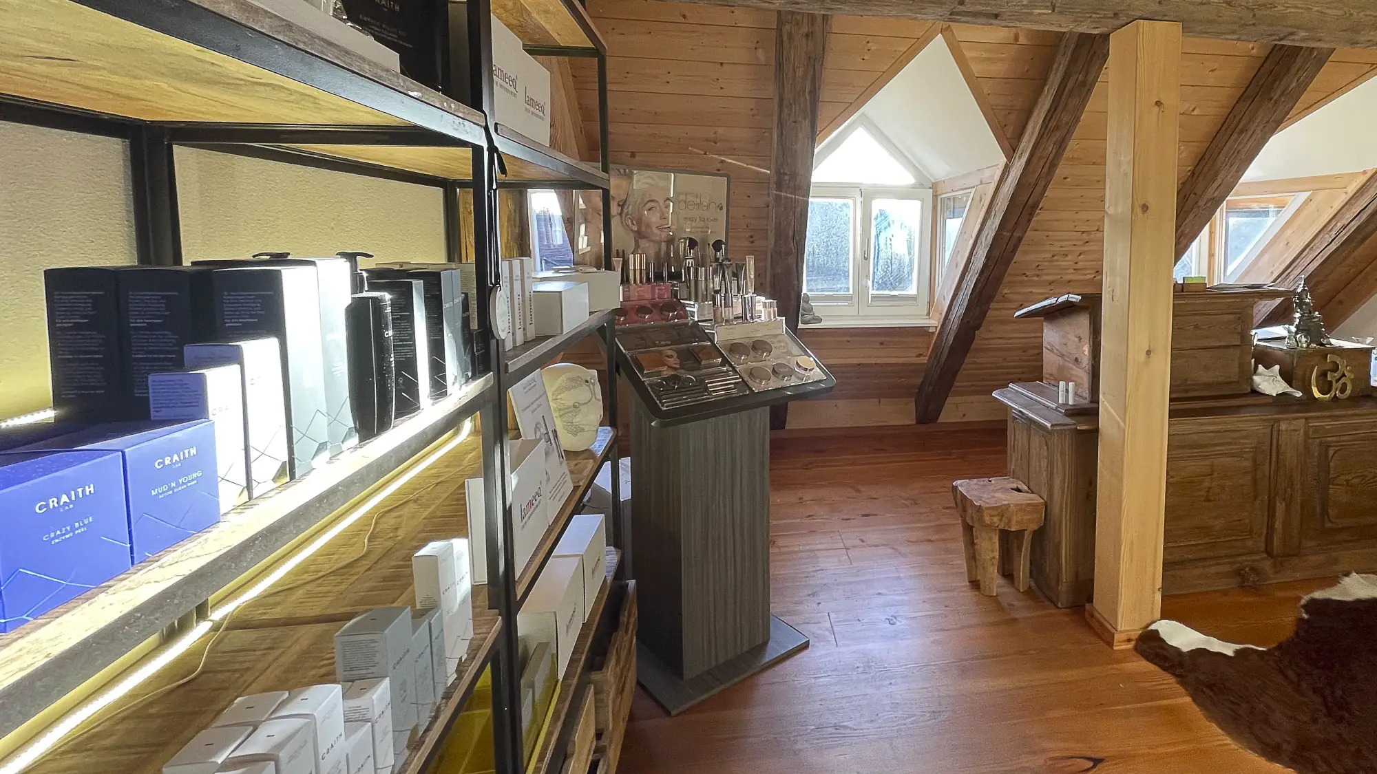 Der Verkaufsbereich von INVERA NATUR unter dem Dach des Hauses am Obermarkt in Murnau mit Regalen und freiliegendem Gebälk